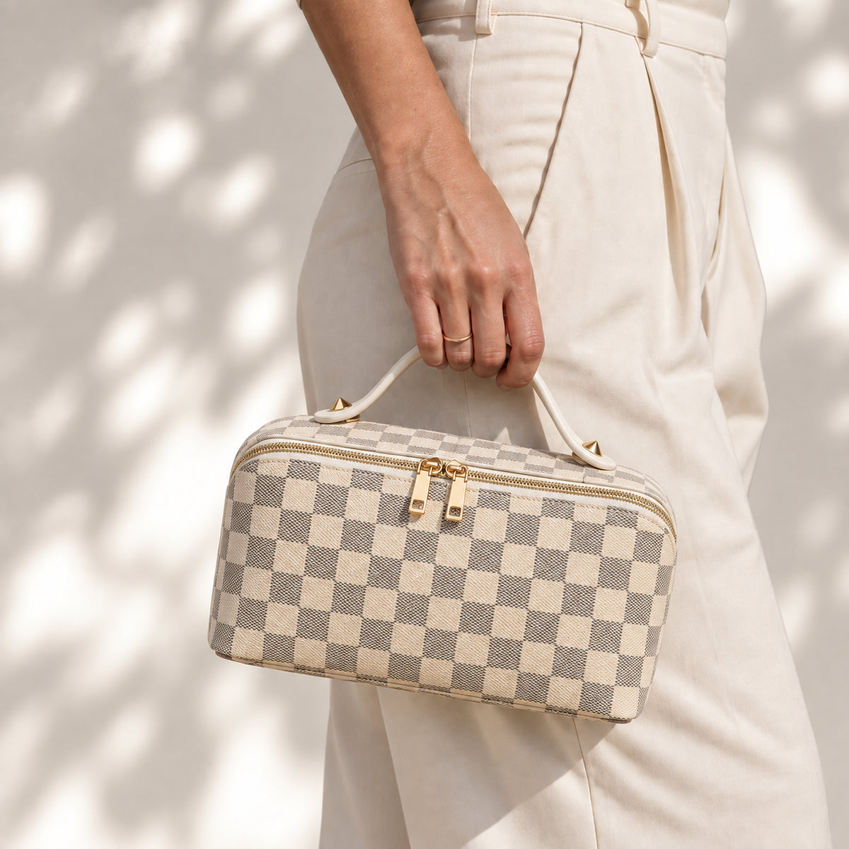 Packly Checkered Beige makeup bag carried by its top handle